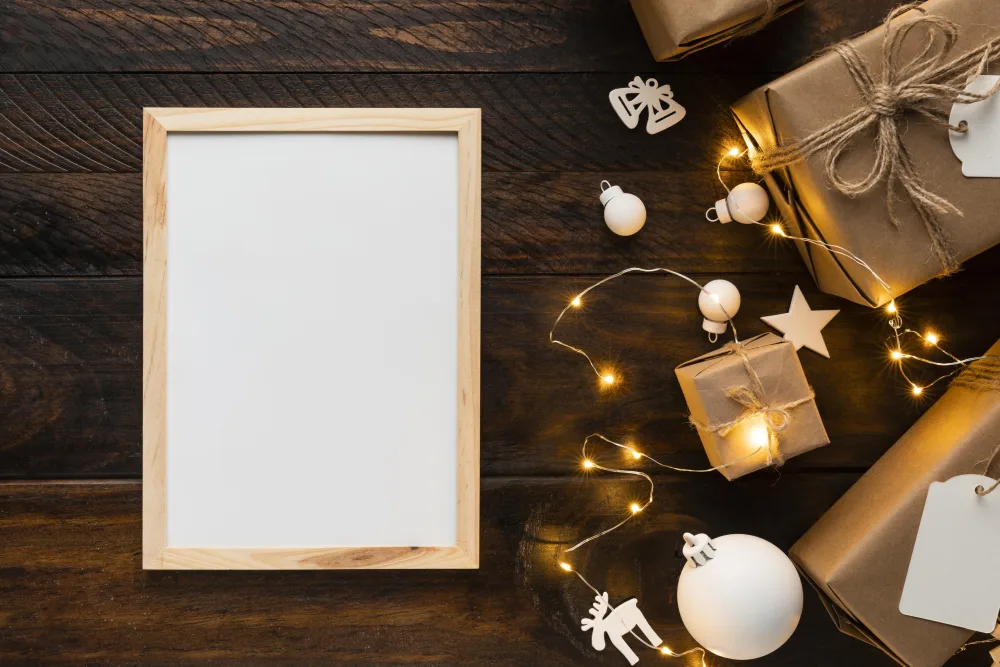 Blank Wooden Frame with Christmas Decorations and Gifts on Wooden Table