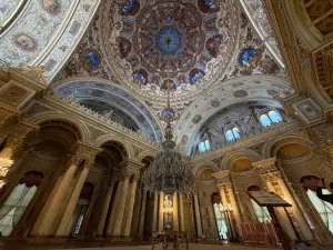 Interior of Ornate Palace Hall with Grand Chandelier and Painted Dome Ceiling