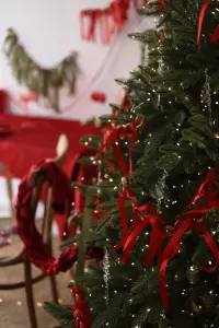 Christmas Tree with Red Ribbon and Fairy Lights in Festive Room
