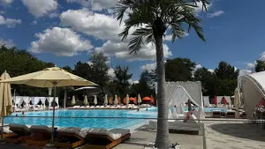 Luxury Outdoor Swimming Pool with Sunbeds and Umbrellas on a Sunny Day