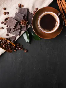 Dark Coffee and Chocolate with Coffee Beans and Spices on Black Background