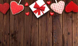 Valentine's Day Gift with Hanging Red Fabric Hearts on Wooden Background