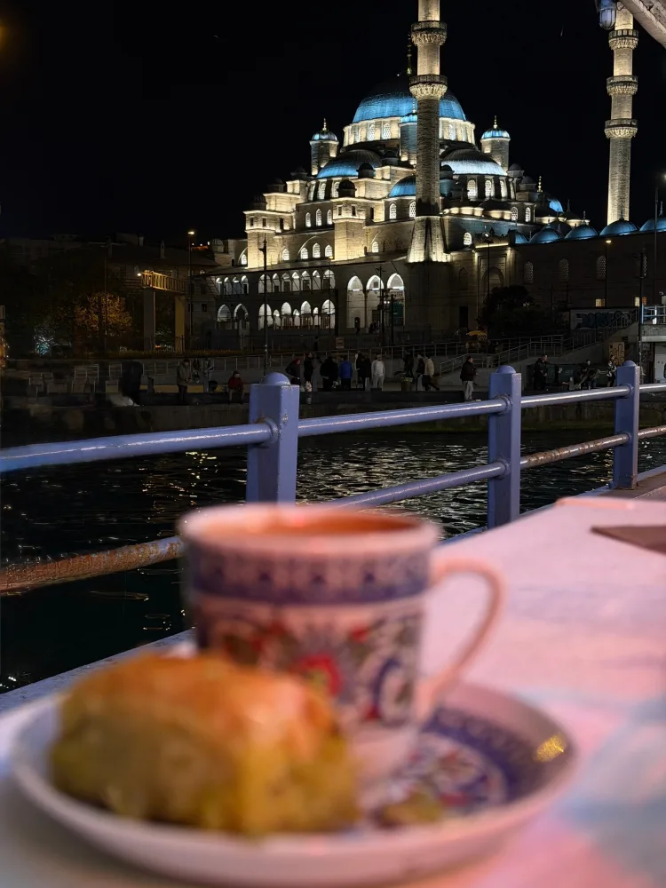 Night View of Illuminated Mosque with Traditional Turkish Tea and Pastry